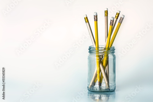 The golden yellow pencil in glass jar on white background with copy space , creative work idea or writing and drawing concept © Cozine