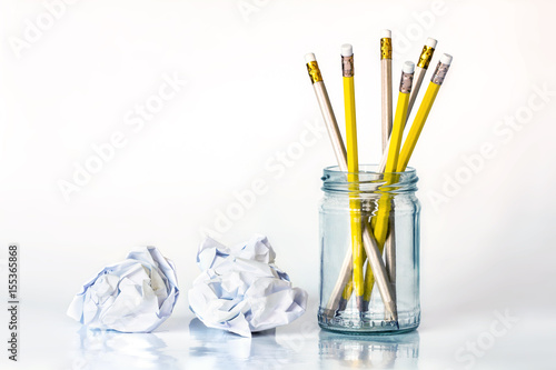 golden yellow pencil in glass jar with the crumpled paper on white background with copy space , creative work idea or writing and drawing concept © Cozine
