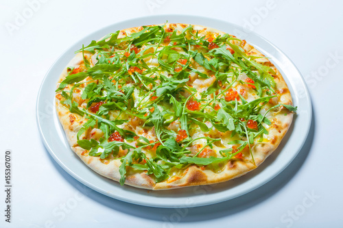 Pizza with seafood and arugula isolated on white