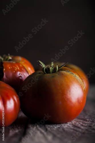 Natural and organic tomatoes on a dark wooden background