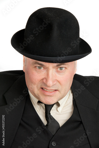 An elderly man in a black hat is very angry