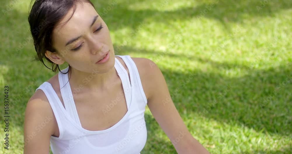 Beautiful young woman in white shirt with grin with copy space in green grass at background Beautiful young woman in white shirt with grin with copy space in green grass at background