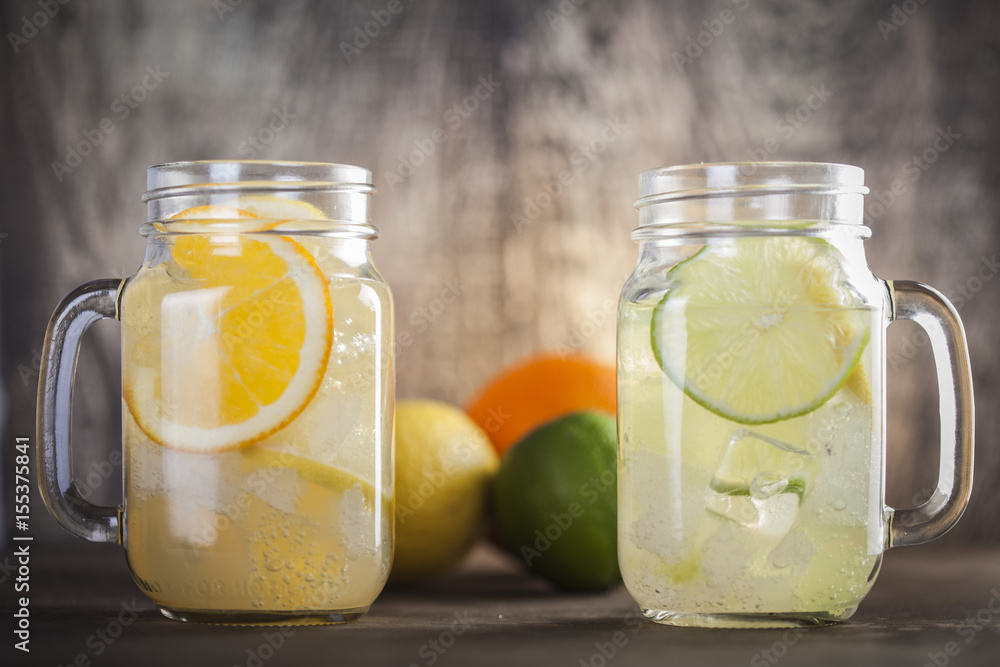 Lemonade in a mason jar with fruit slices on a wooden table Lemonade in a mason jar with fruit slices on a wooden table