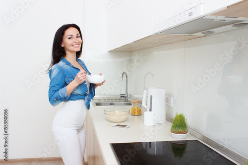 Wellness concept. Beautiful young woman making breakfast and smiling. Healthy eating. Dieting concept.