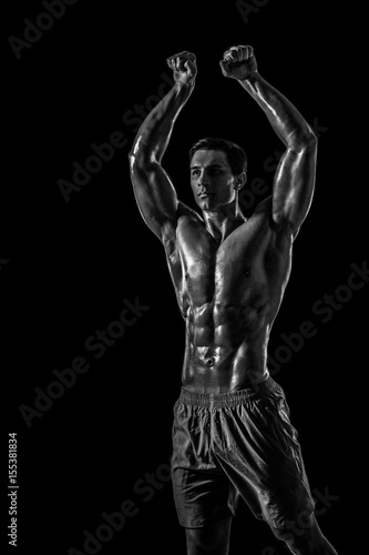 Muscular and fit young bodybuilder fitness male model posing ove