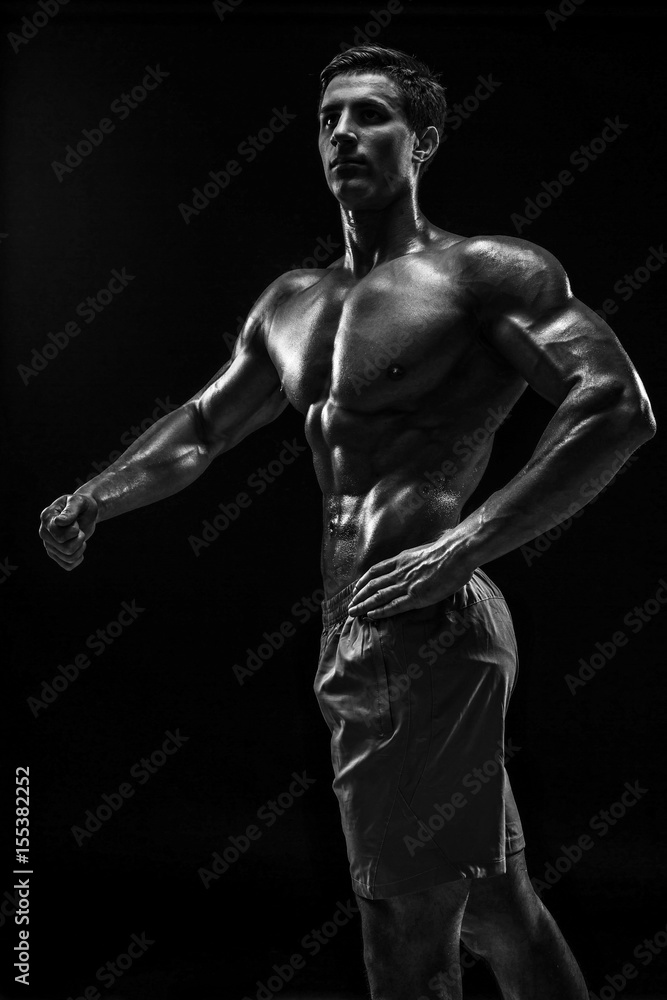 Fototapeta premium Muscular and fit young bodybuilder fitness male model posing ove