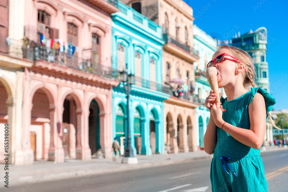Adorable little girl eating ice-cream in popular area in Old Havana, Cuba. Portrait of cutiest kid outdoors on a street of Havana