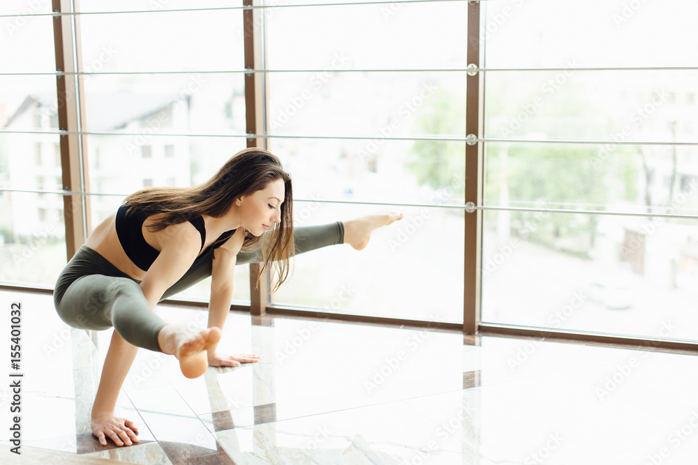Fototapeta premium Gitl stand on hands on white gym background