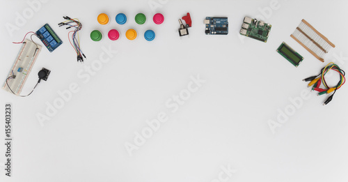 Desk with Electronic components: Arduino, Raspberry Pi, Resistences, Display, Wires, Arcade Buttons, Breadboard with Sensors
