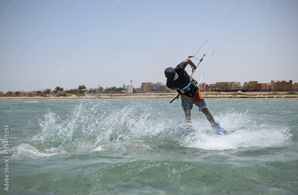 Fototapeta premium Kite sportsman riding in the crystal water, kiteboarding water sports, active lifestyle, blue lagoon kite spot, Egypt