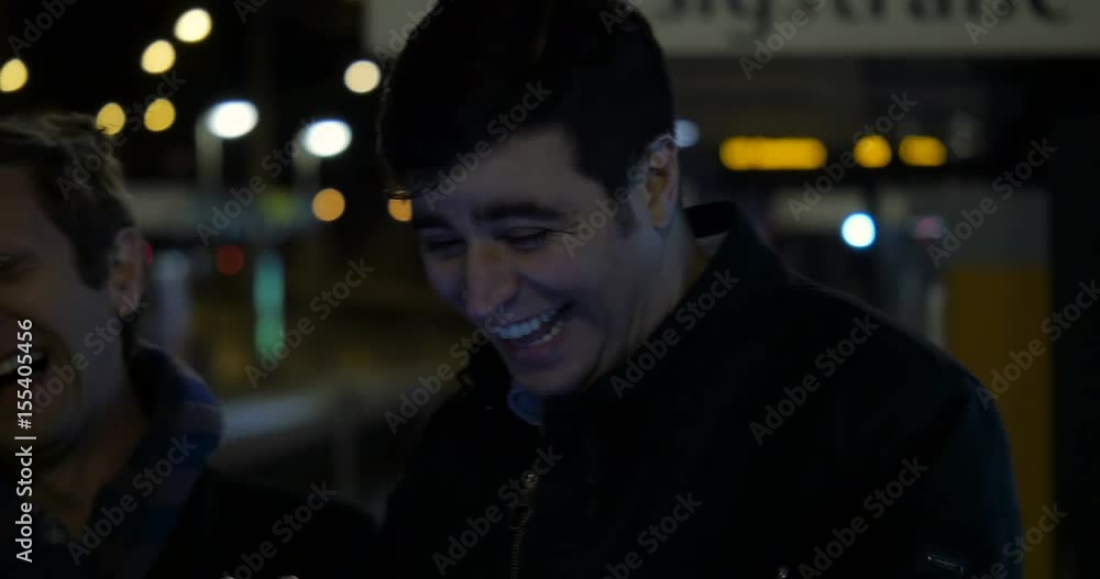 Male friends laughing using mobile phone. Male friends laughing using mobile phone.