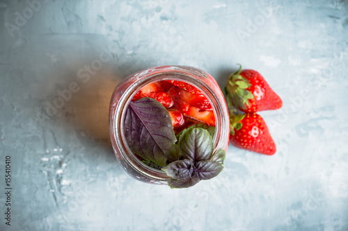 Fototapeta Naklejka Na Ścianę i Meble -  Fresh cocktail with strawberry and basil in glass. Shallow depth of field.
