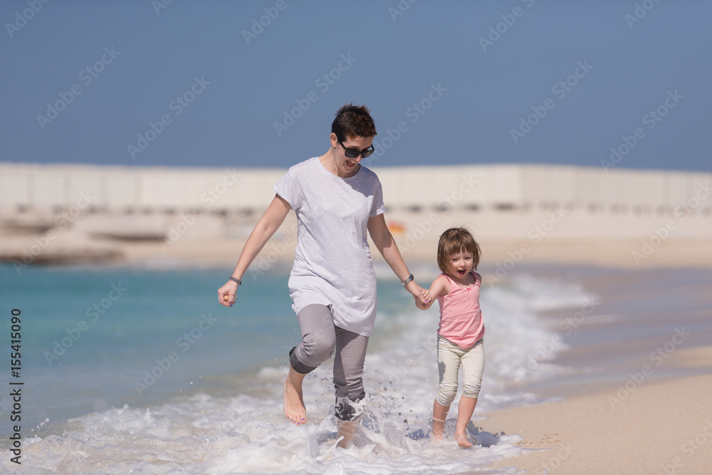 mother and daughter running on the beach