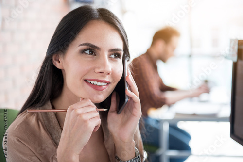 Thoughtful smiling woman keeping phone