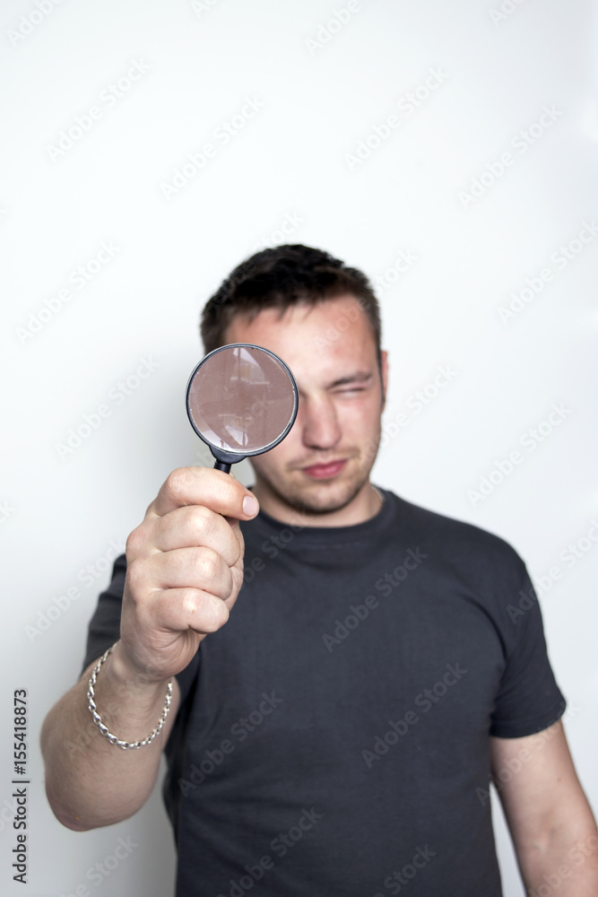 A man looks in a magnifying glass A man looks in a magnifying glass