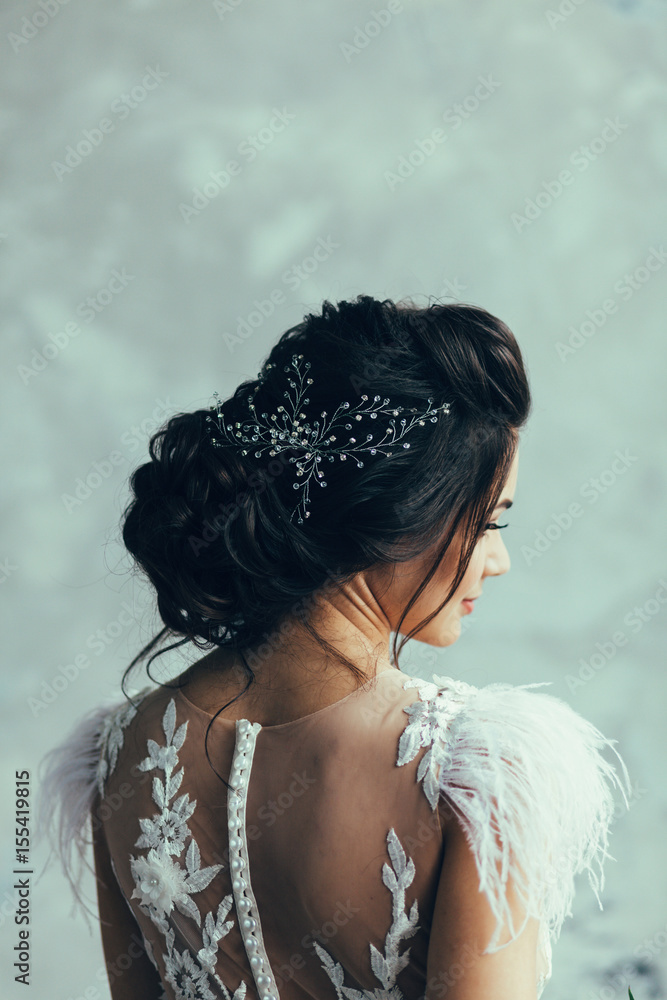 Portrait of the bride in a wedding dress and with a hairdress from the back