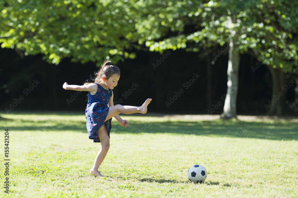 Barefoot Little Girl playing with a soccer ball Barefoot Little Girl playing with a soccer ball