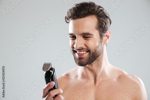 Handsome young man holding electric razor photo