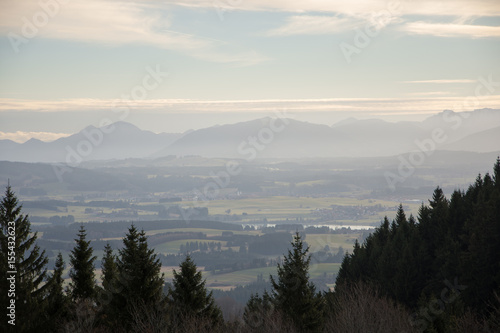 Sunrise in the green valley with mountains on background dramatic foggy sky and clouds.