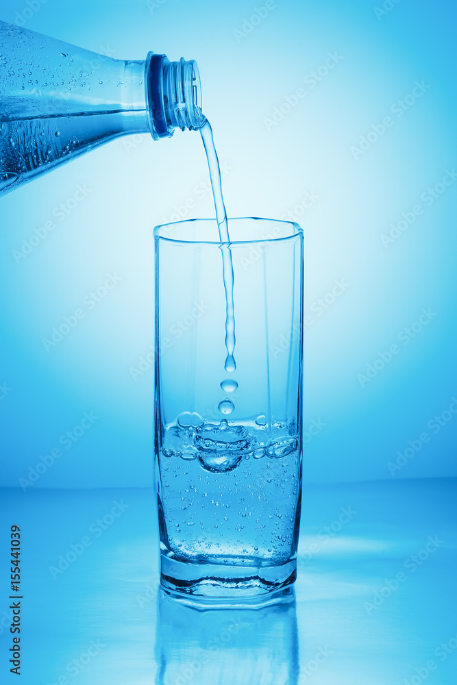 Drinking sparkling water pouring from a bottle into a glass Drinking sparkling water pouring from a bottle into a glass
