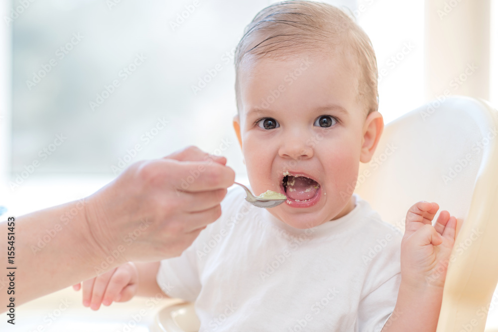 grandmother gives baby food from a spoon grandmother gives baby food from a spoon