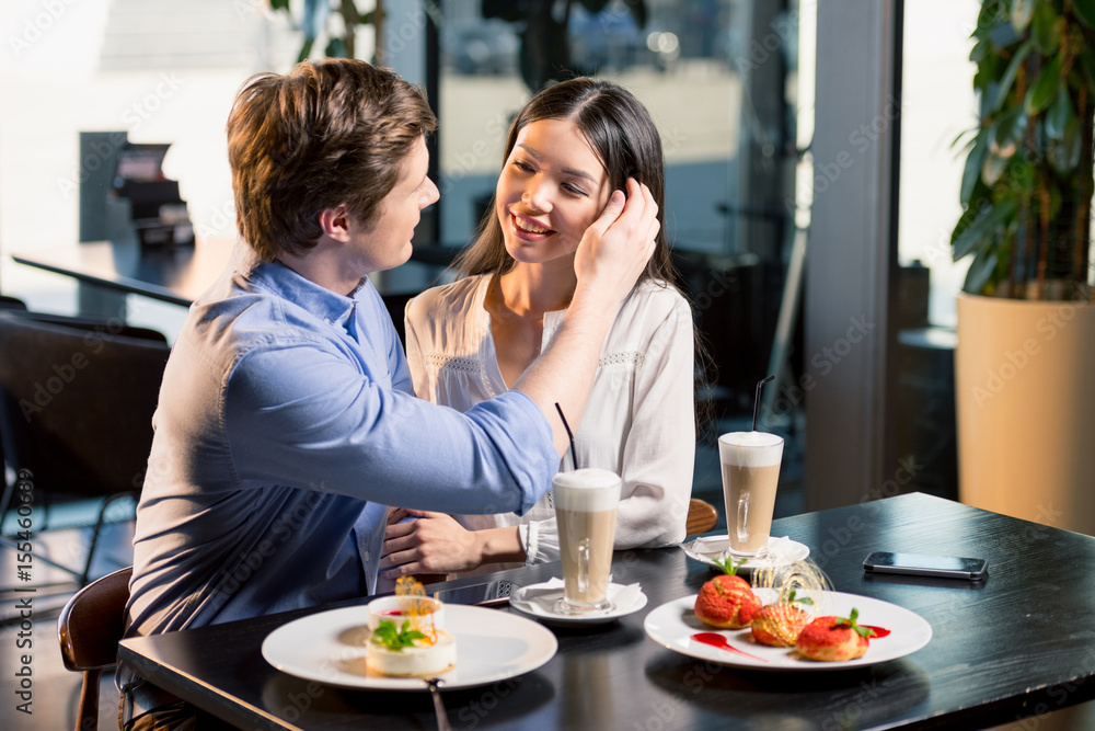 Beautiful happy young couple in love at romantic date in restaurant