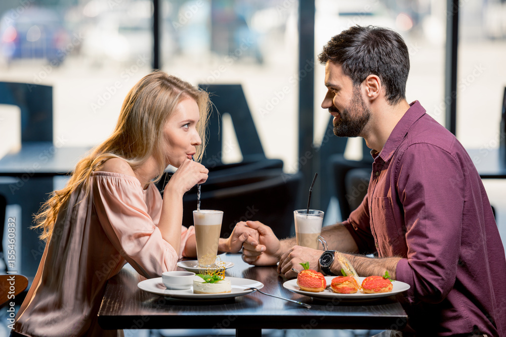 side view of couple in love having lunch together in restaurant side view of couple in love having lunch together in restaurant