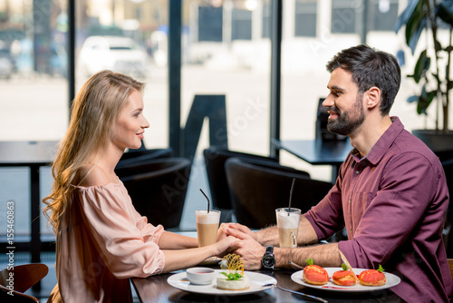side view of couple in love having lunch together in restaurant