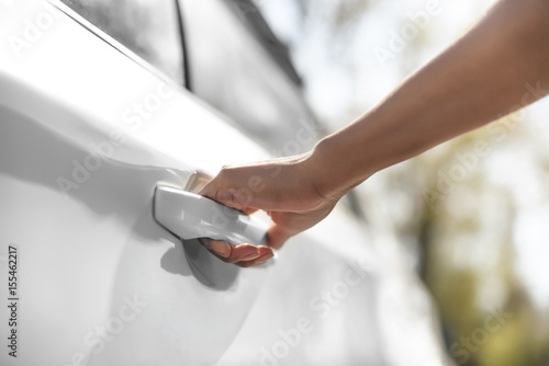 partial view of woman opening car door on parking