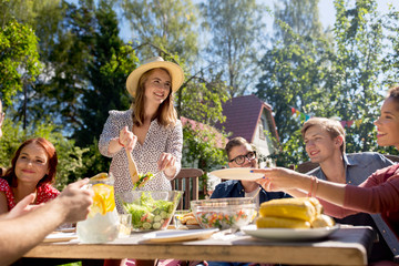 happy friends having dinner at summer garden party