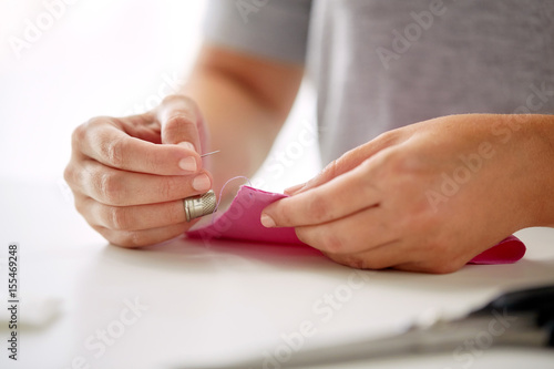 woman with needle stitching fabric pieces