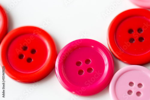 red and pink sewing buttons on white background