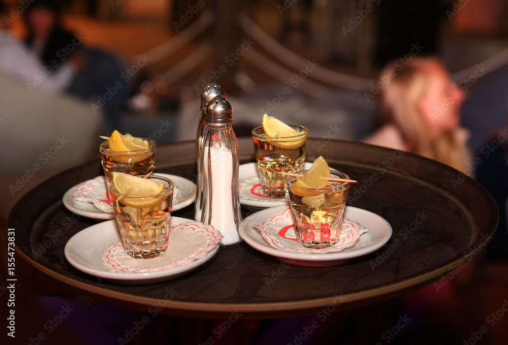 Tequila with lemon and salt, four portions on a bar tray
