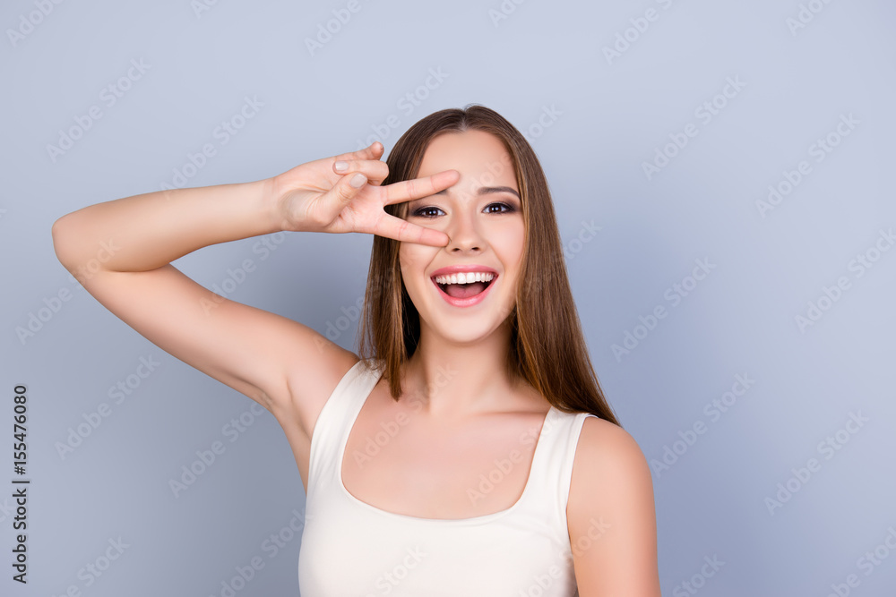 Fun time! Disco star! Young attractive girl in white casual singlet is standing on pure background and is fooling around Fun time! Disco star! Young attractive girl in white casual singlet is standing on pure background and is fooling around