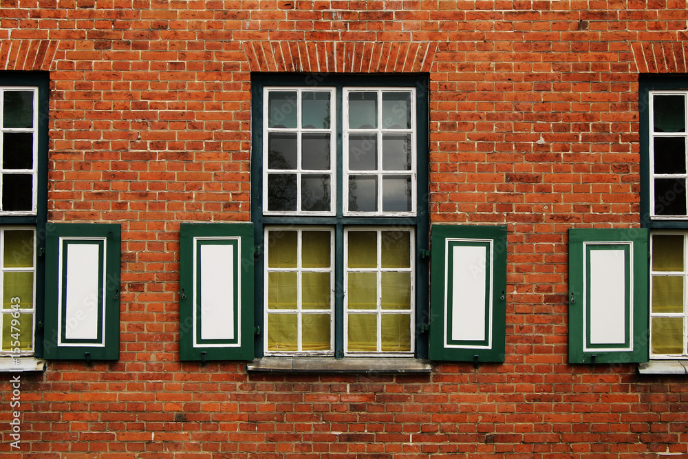 Fragment of a building with windows of an ancient palace of red brick