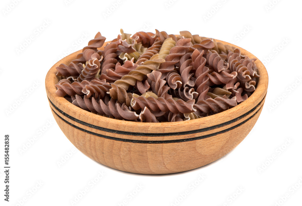 Wooden bowl filled with raw pasta fusilli on white background Wooden bowl filled with raw pasta fusilli on white background