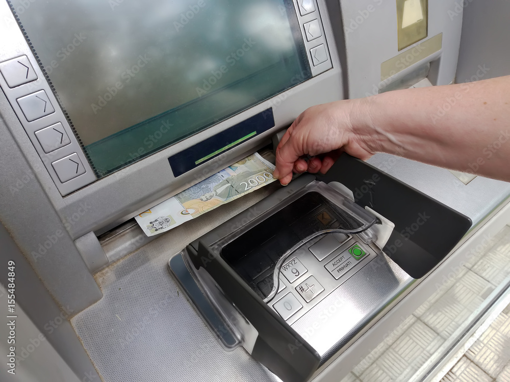 woman hand withdrawing money from outdoor bank ATM woman hand withdrawing money from outdoor bank ATM