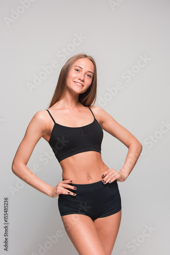 Muscular young woman athlete on gray © master1305
