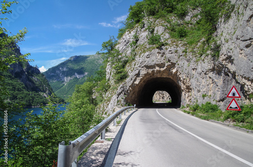 Road tunnel in the rock. Highway tunnel cutting through a mountain. Montenegro, Lake Piva