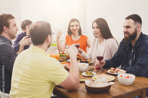 Group of happy young people at dinner table  friends party