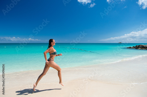 Young woman running at the tropical beach © be free