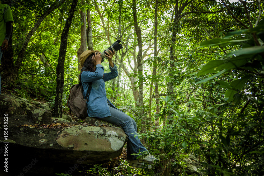 young woman backpacker taking a picture of view of natural scenery