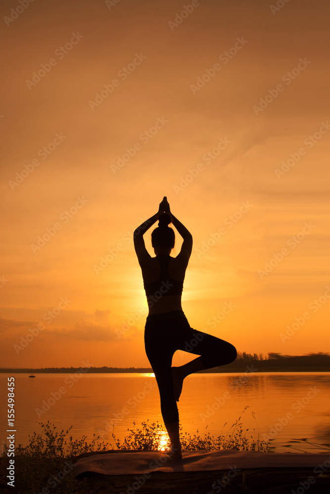 Young woman in a meditating yoga the beautiful sunset Young woman in a meditating yoga the beautiful sunset