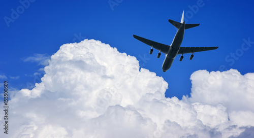 Airplane silhouette in deep blue sky.