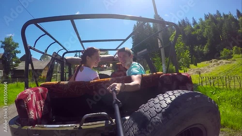 Young couple on the road in a jeep with an open top in the mountains. The guy and the girl are traveling on a pickup truck.