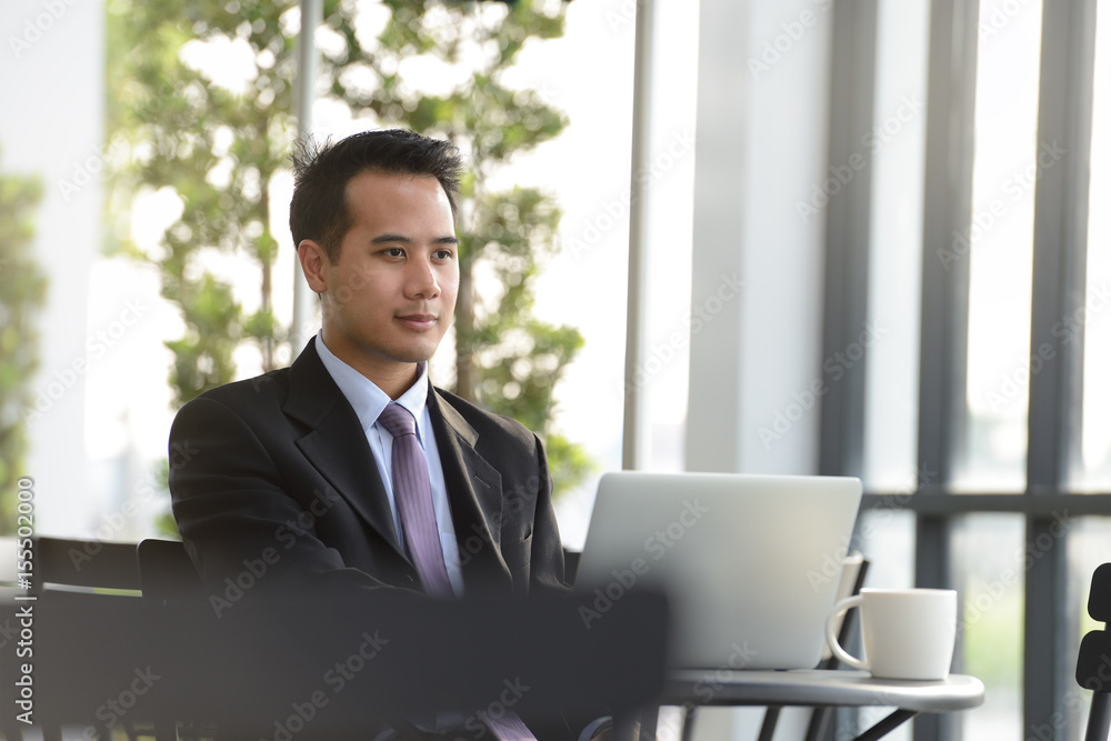 Young Asian businessman working with laptop computer at outdoor cafe Young Asian businessman working with laptop computer at outdoor cafe