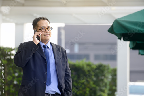  Executive businessman talking on a mobile phone at outdoor office