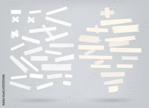 Set of multiple white and beige adhesive sticky tape ripped pieces on grey background with shadow 