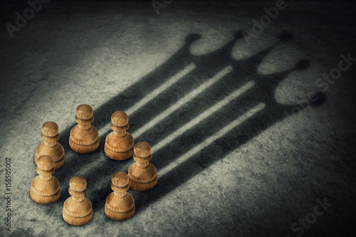 Chess pawn standing together, arranged in a circle joining the power, casting a crown shaped shadow. Business group leadership and team working concept. Belief in success.
