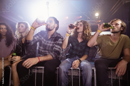Male friends drinking beer at nightclub
